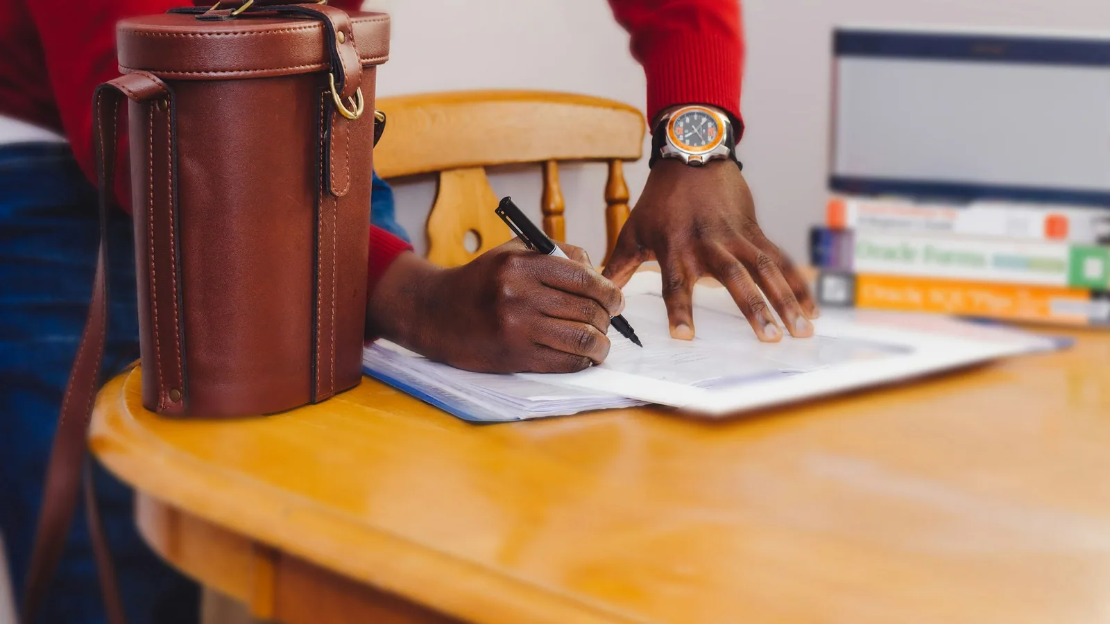 Hands completing employee onboarding paperwork at an office desk
