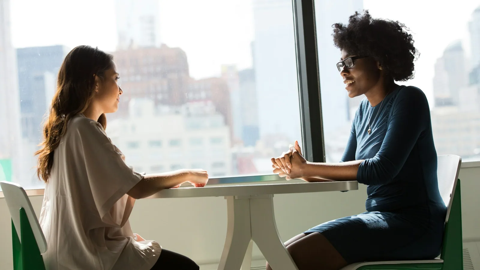 Two people in conversation across a table during a research interview